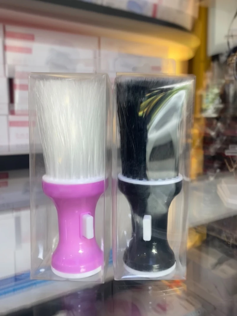 Two barber neck brushes with white bristles, one pink and one black