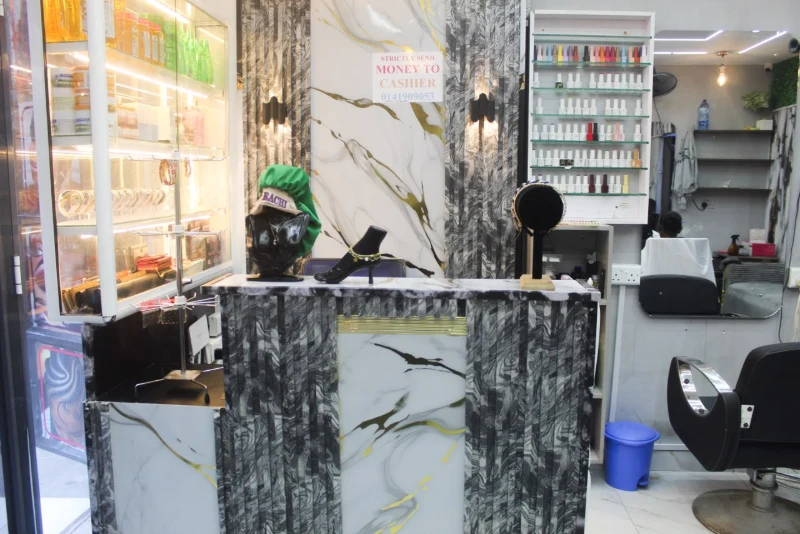 Reception counter with the salon floor and styling chairs beyond