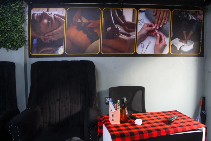 Plush black chair in a relaxation corner under a treatment menu banner