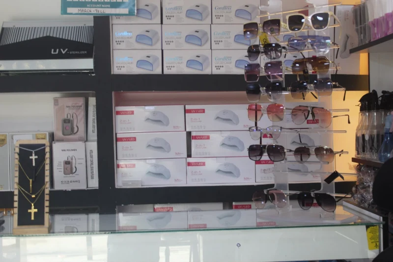 Shelves of UV nail lamp boxes and grooming products in the shop
