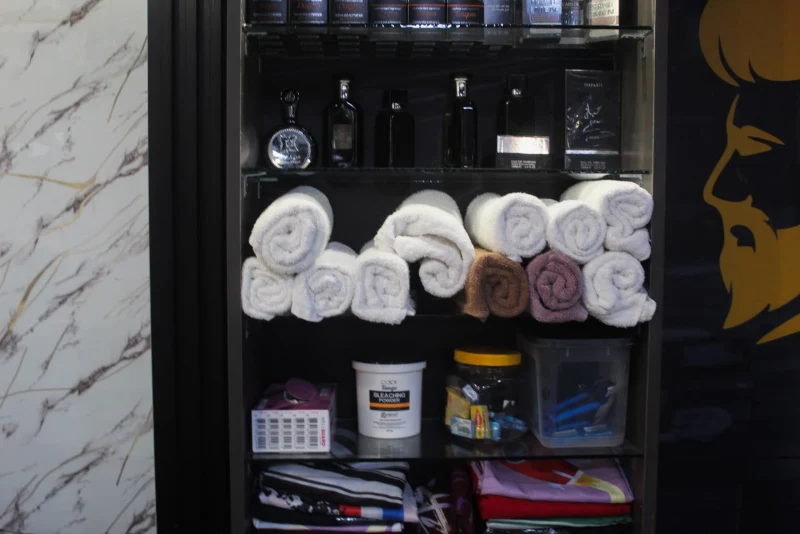 Fresh white towels and grooming products on a shelf